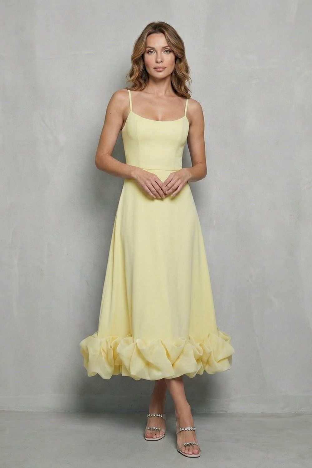 Elegant women's yellow sleeveless midi dress with a sweetheart neckline and a distinctive ruffled hem, perfect for a midi wedding guest dress.
