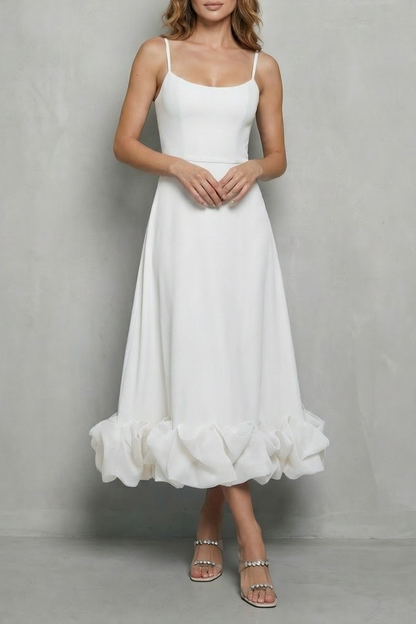 White sleeveless midi dress with thin straps and a voluminous ruffled hem, suitable as a white satin dress or elegant dress for wedding guests.
