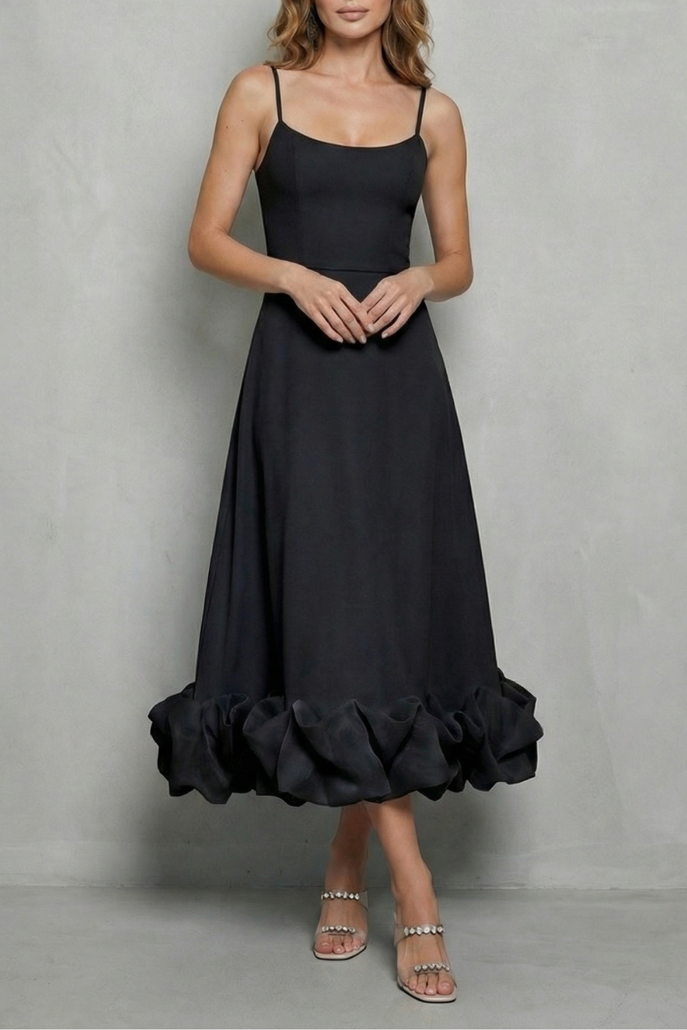 Black sleeveless midi dress featuring delicate spaghetti straps and a dramatic ruffled hem, ideal for a black satin dress or midi dress with sleeves.