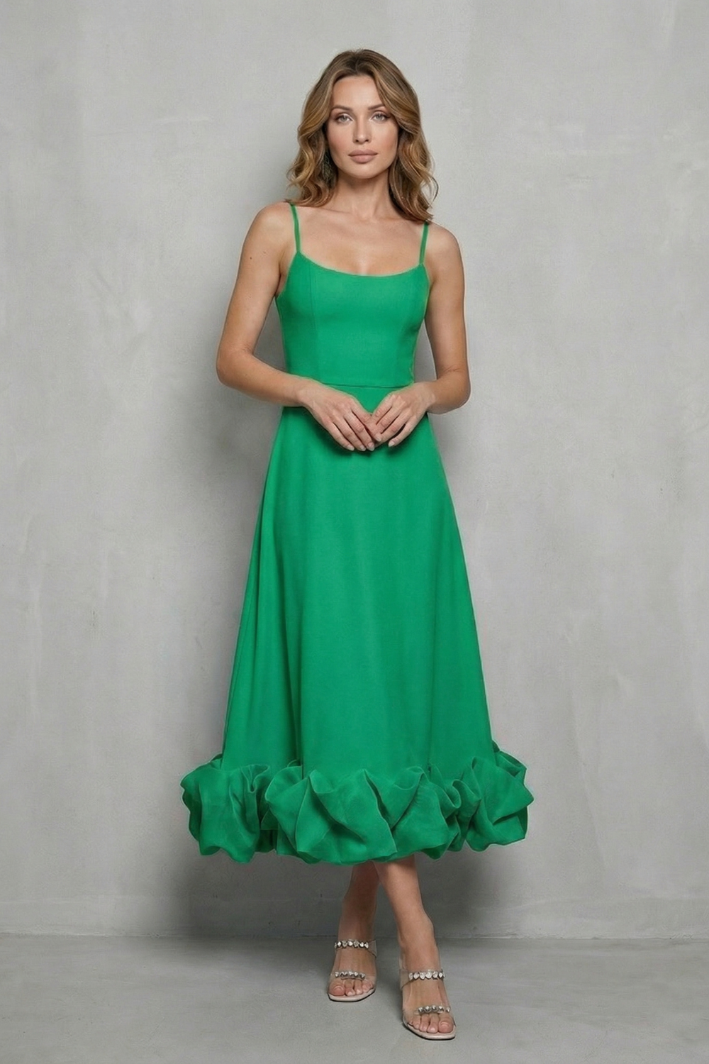 Front view of a woman in a bright green sleeveless midi dress with a unique ruffled hem, an elegant midi wedding guest dress option.