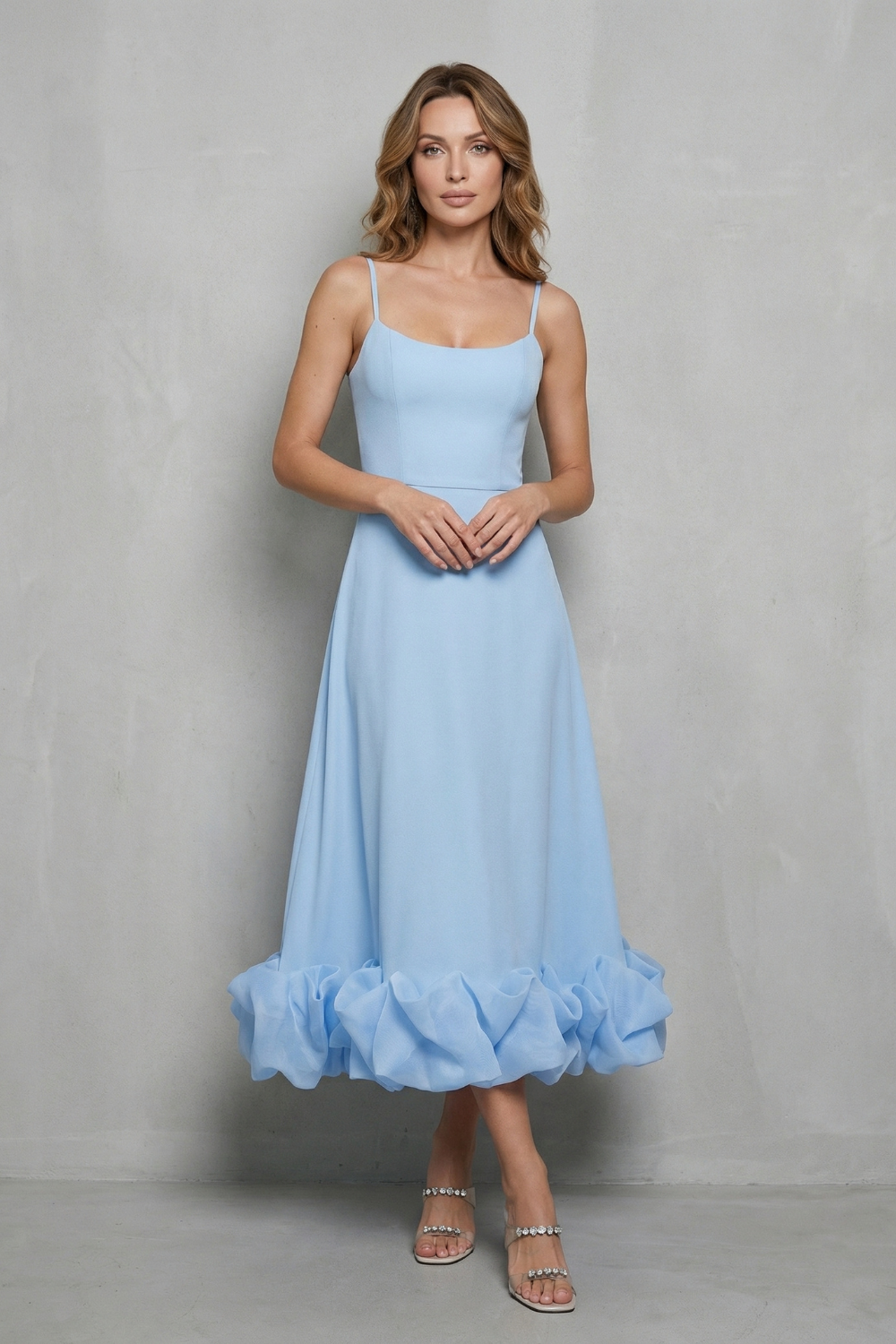 Front view of a women's light blue sleeveless midi dress, featuring delicate spaghetti straps and a full ruffled hem, ideal for wedding guest dresses.