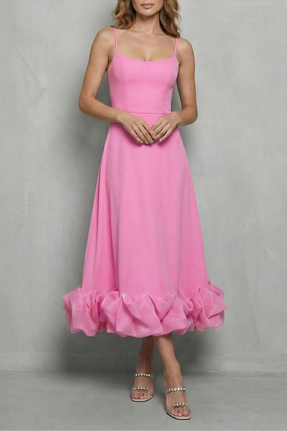 Vibrant pink sleeveless midi dress with a sweetheart neckline and a playful ruffled hem, a stylish choice for vacation outfits.