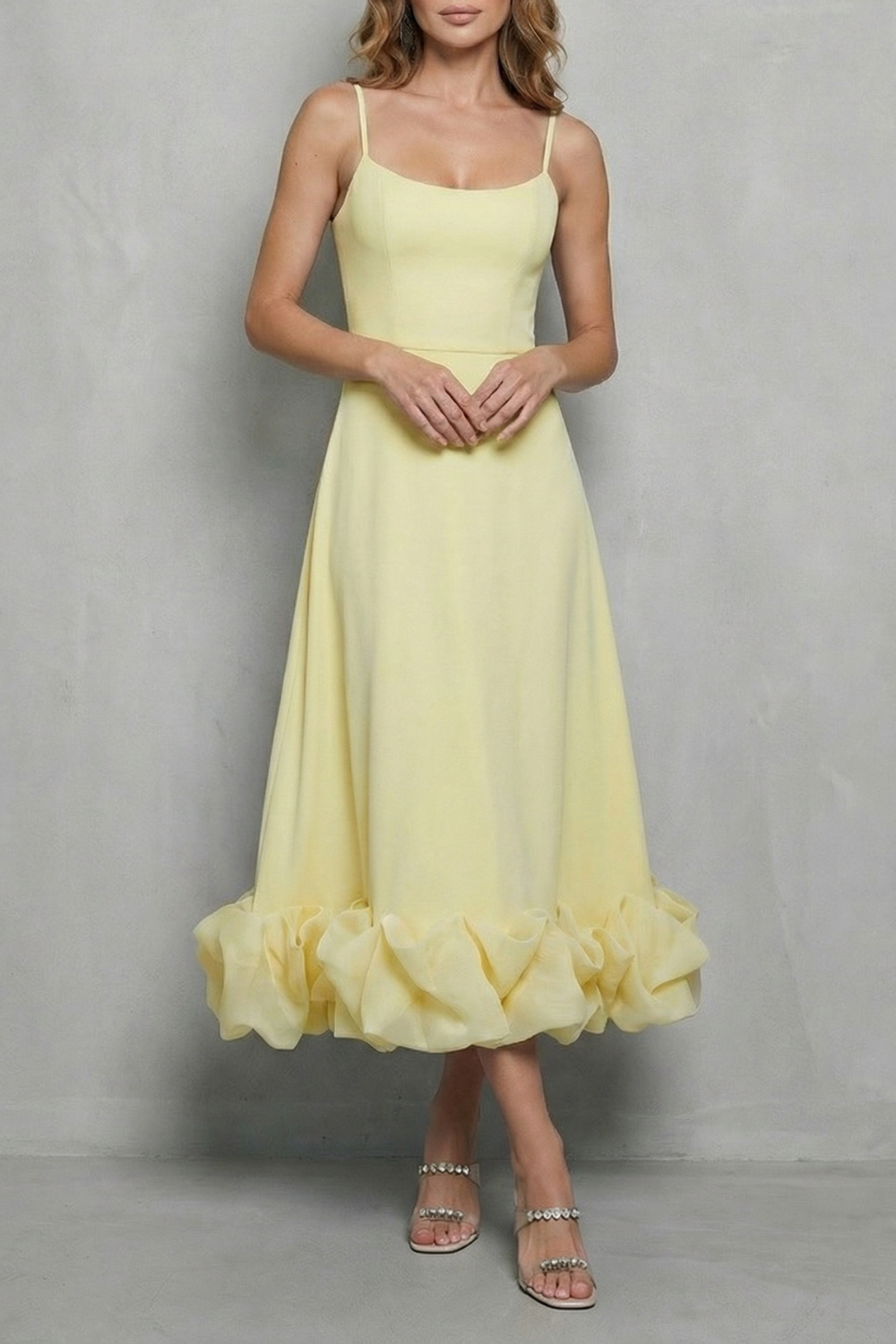 Soft yellow sleeveless midi dress with a fitted bodice, spaghetti straps, and a unique ruffled hem, a lovely option for beach dress for women.