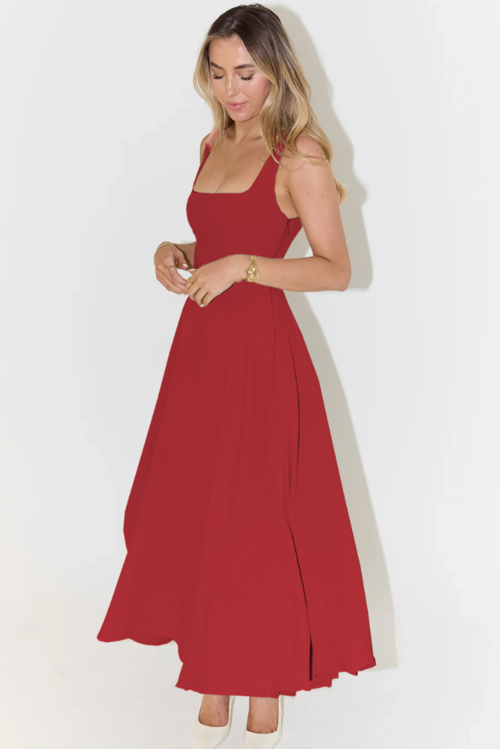 Red square neck sleeveless midi dress for women, featuring a flowing A-line skirt and subtle side slit, paired with white heels.
