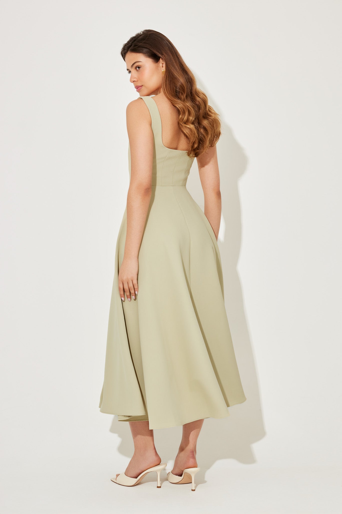 Back view of a light green square neck midi dress, showing the elegant silhouette and hemline.