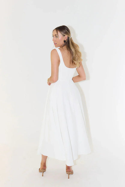 Back view of a white square neck midi dress, showing the elegant cut and movement of the skirt.