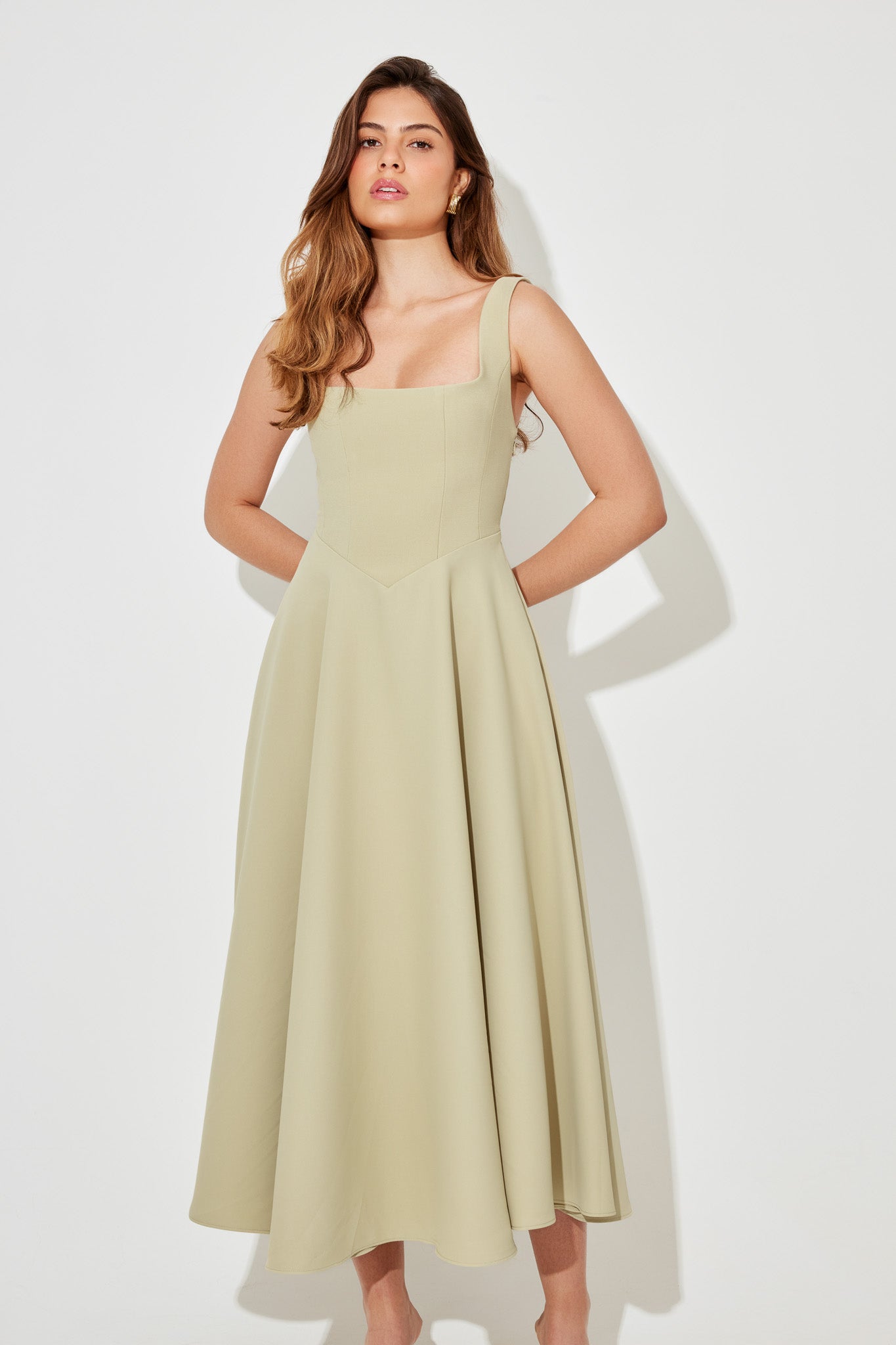 Light green square neck sleeveless midi dress with a flowing A-line skirt, perfect for vacation outfits.