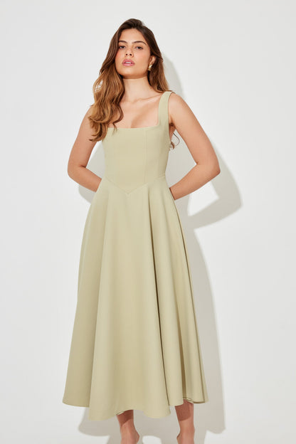 Light green square neck sleeveless midi dress with a flowing A-line skirt, perfect for vacation outfits.