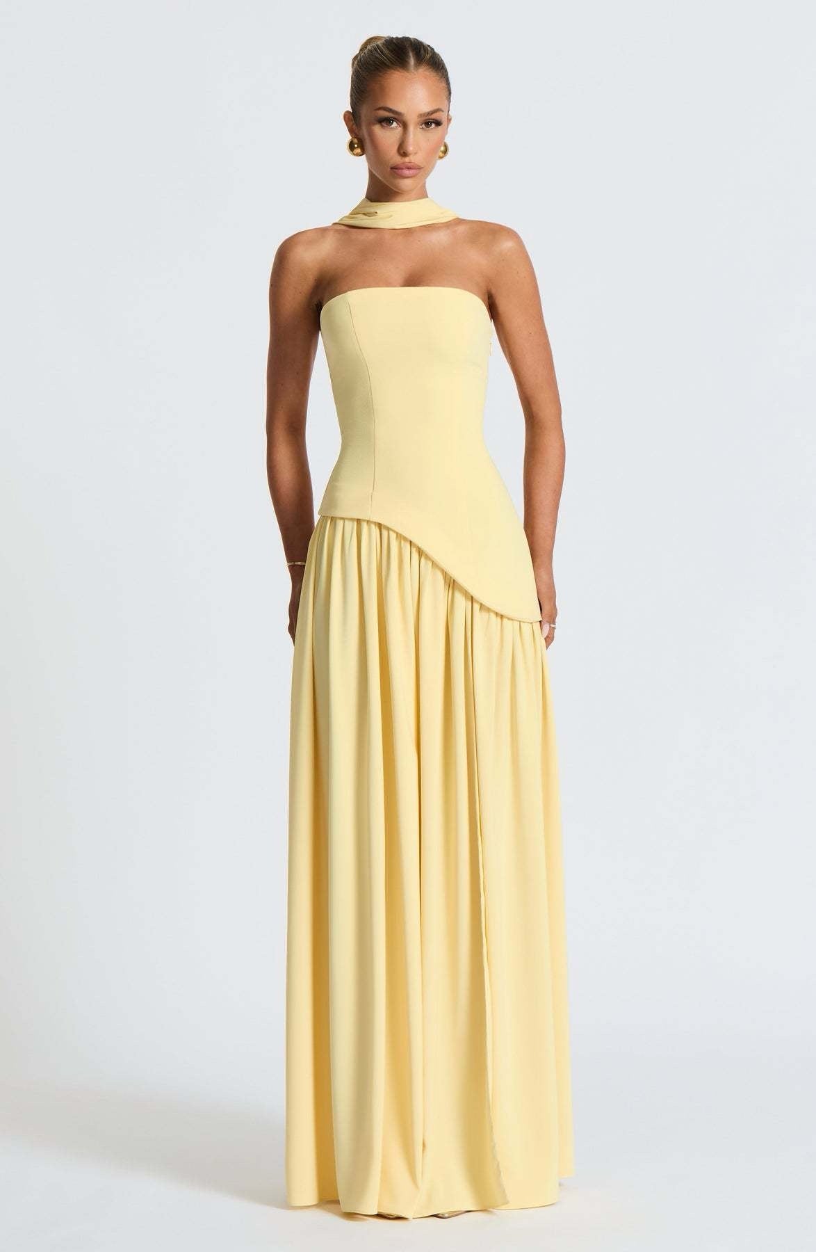 Front view of the yellow strapless asymmetric corset maxi dress, highlighting the structured corset bodice and draped skirt.