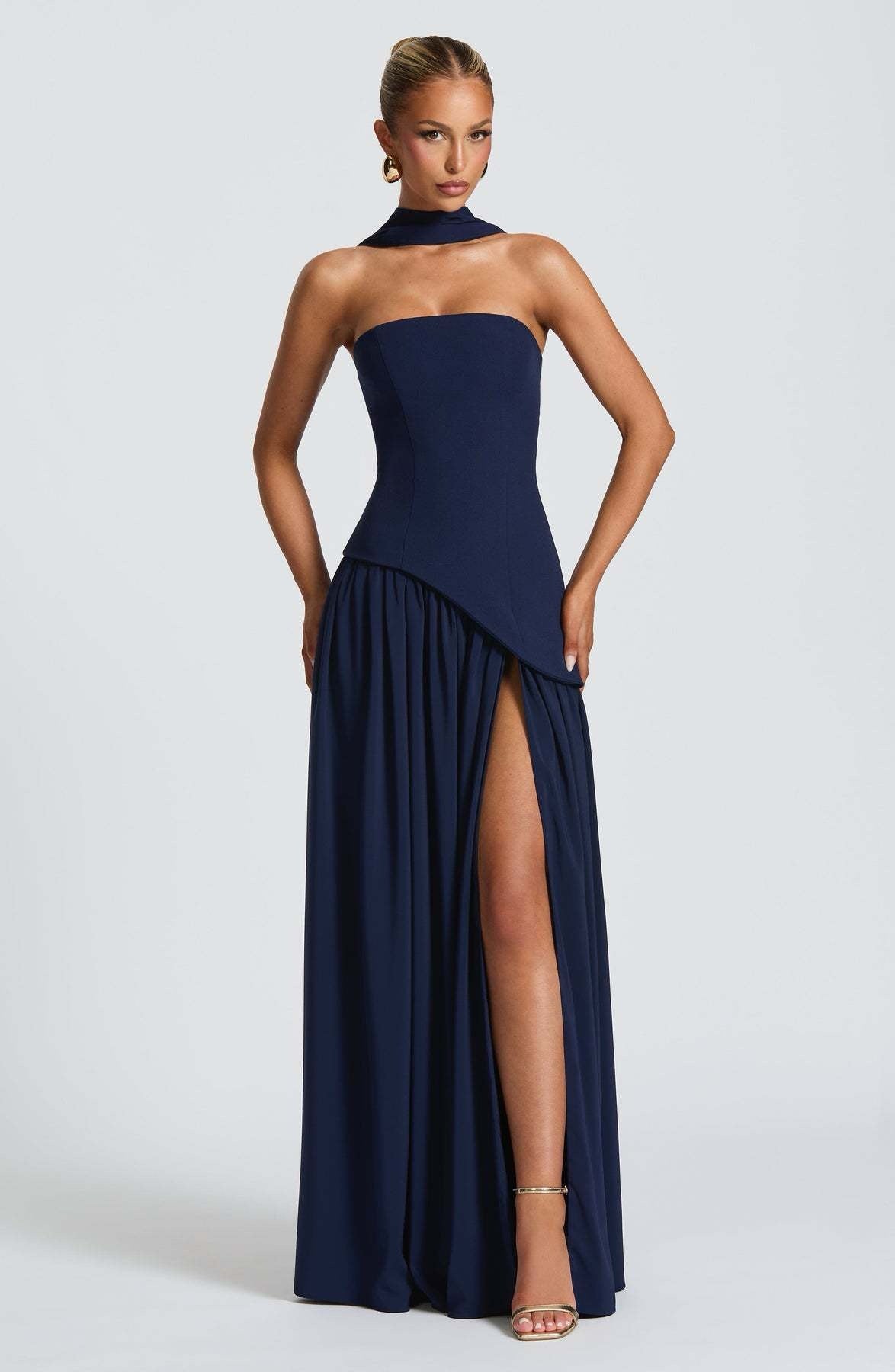 Elegant navy blue strapless asymmetric corset maxi dress, featuring a structured bodice and a high leg slit.