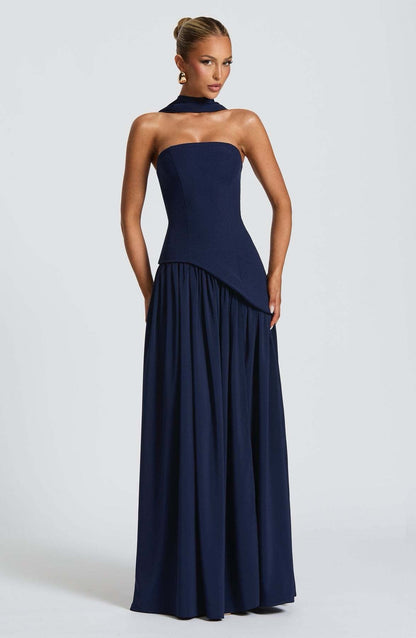 Navy blue strapless asymmetric corset maxi dress with a flowing skirt and a matching choker neck scarf.