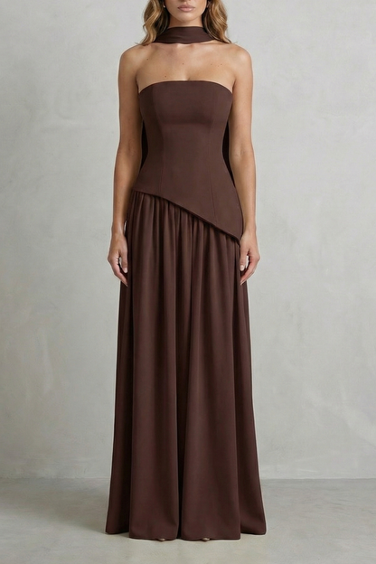 Deep brown strapless asymmetric maxi dress with a tailored bodice and a flowing skirt, offering an elegant look.
