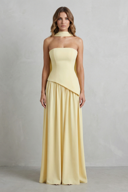 Full-length shot of a light yellow strapless asymmetric maxi dress with a subtle choker, ideal for vacation outfits.