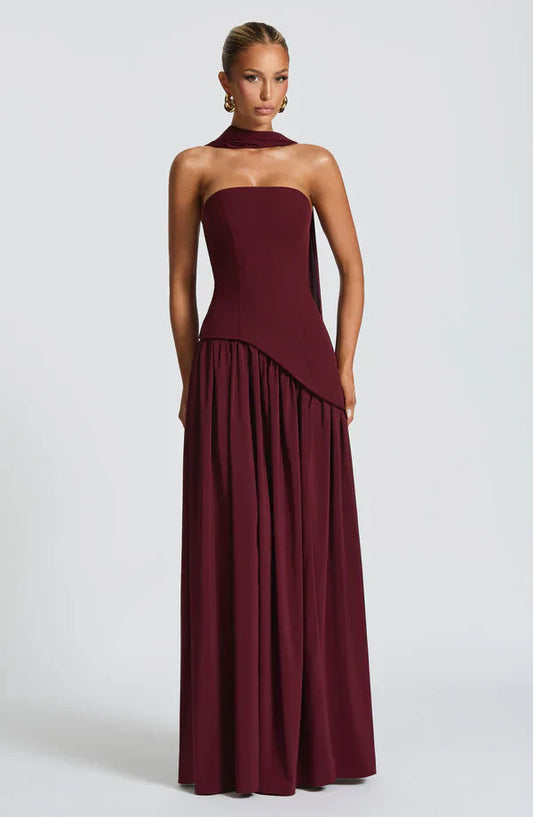 Burgundy strapless maxi dress with asymmetrical waistline and matching choker, elegant for wedding guests.