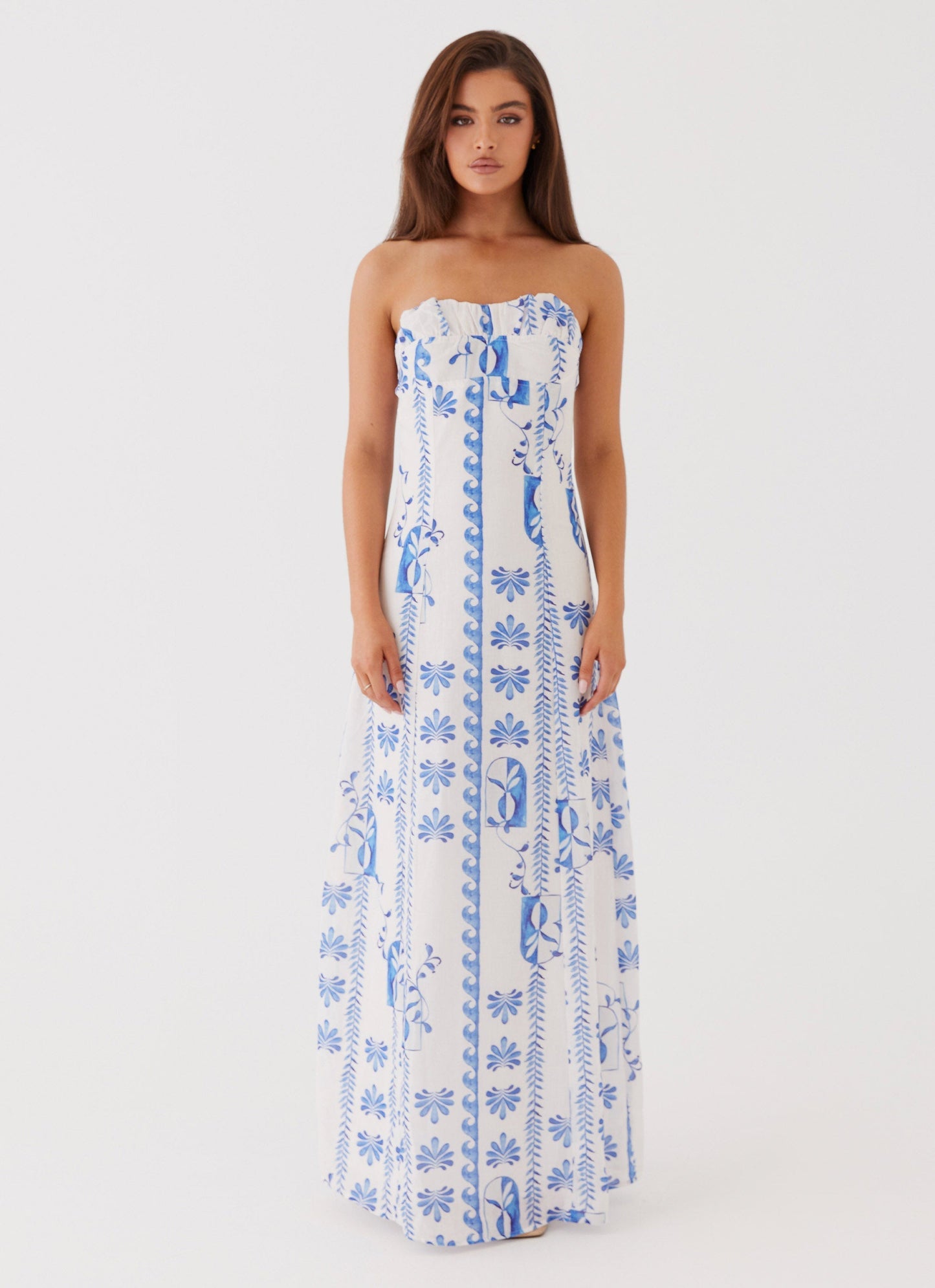 Front view of women's strapless white maxi dress with delicate blue floral patterns, perfect for vacation outfits.
