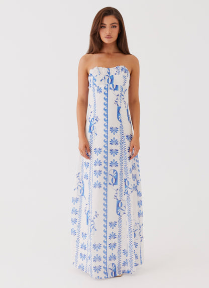 Front view of women's strapless white maxi dress with delicate blue floral patterns, perfect for vacation outfits.