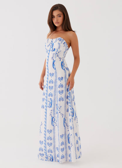 Side view of a women's strapless A-line maxi dress, featuring a white background with blue floral designs.