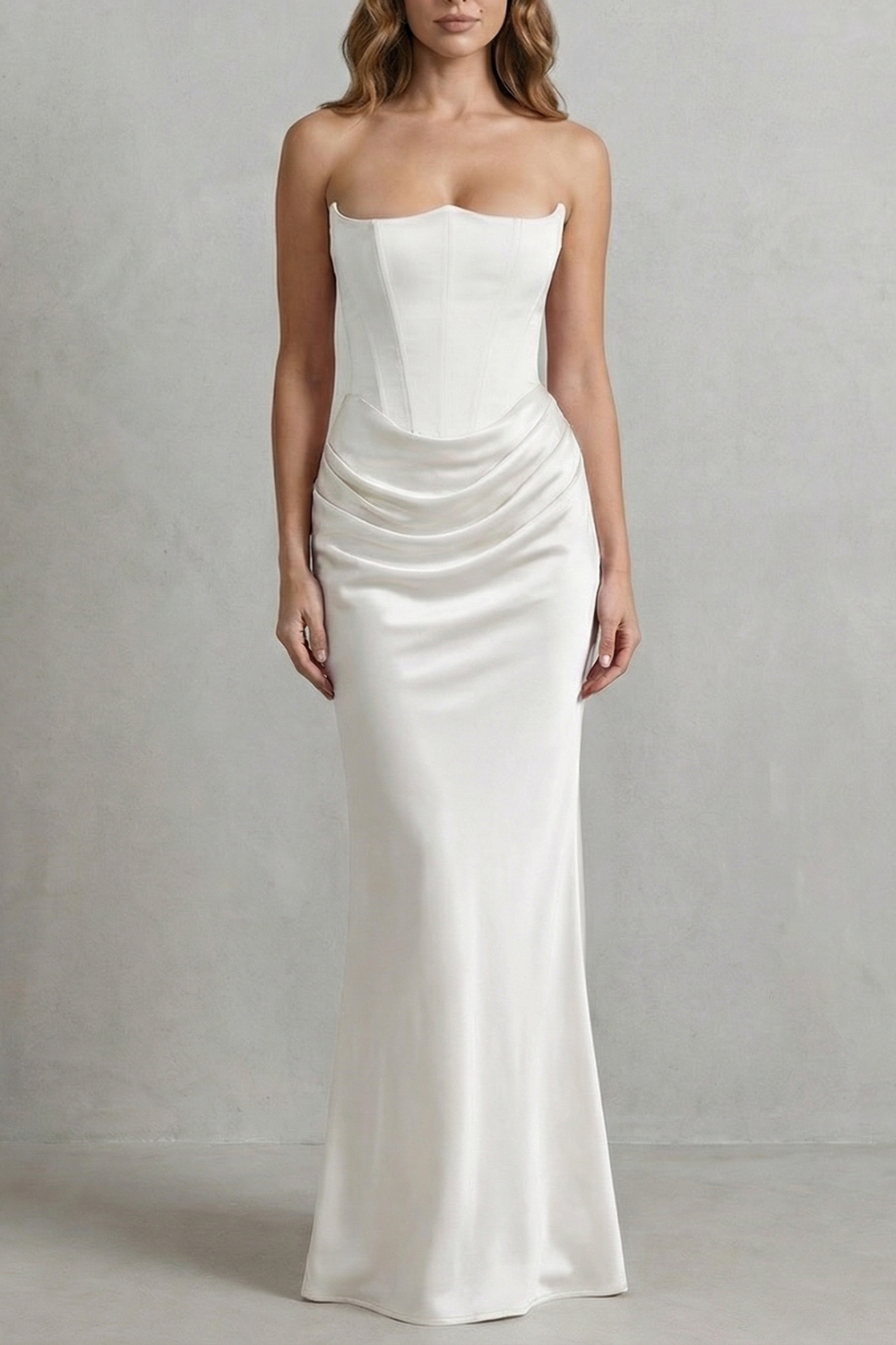 Elegant white satin maxi dress with a strapless corset bodice and draped skirt detail, perfect for wedding guests.