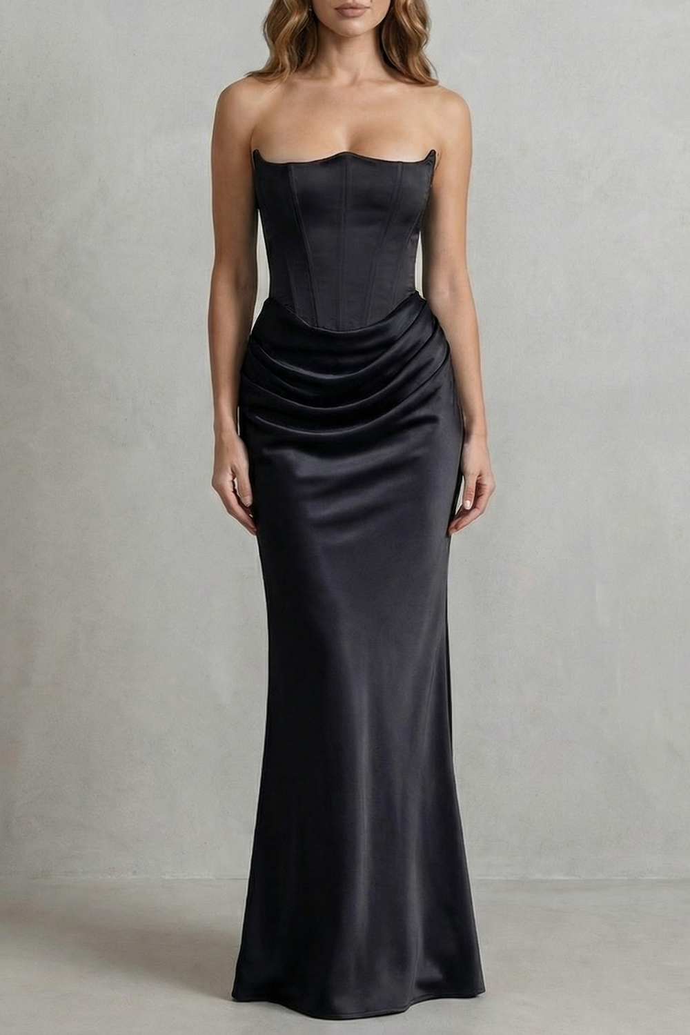 Full-length view of a black satin dress with a strapless corset bodice and gracefully draped maxi skirt.