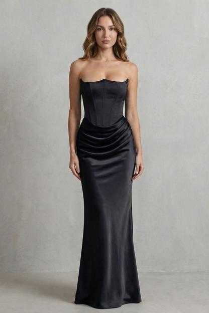 Front view of a woman in an elegant black satin dress, featuring a strapless corset design and draped skirt, perfect for formal events.