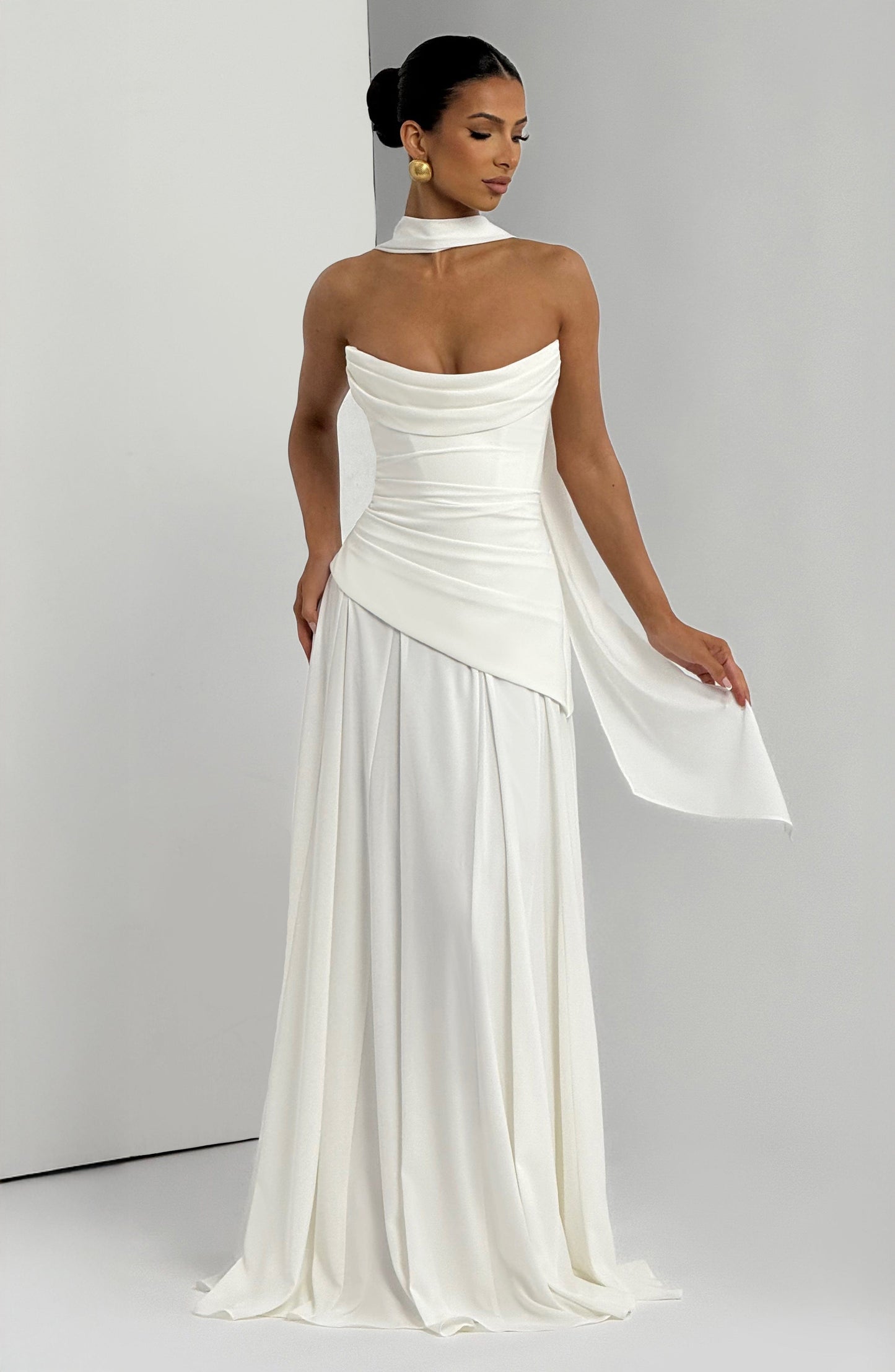 Elegant white strapless cowl neck maxi dress for women, featuring a flowing skirt and a long, draped sash.