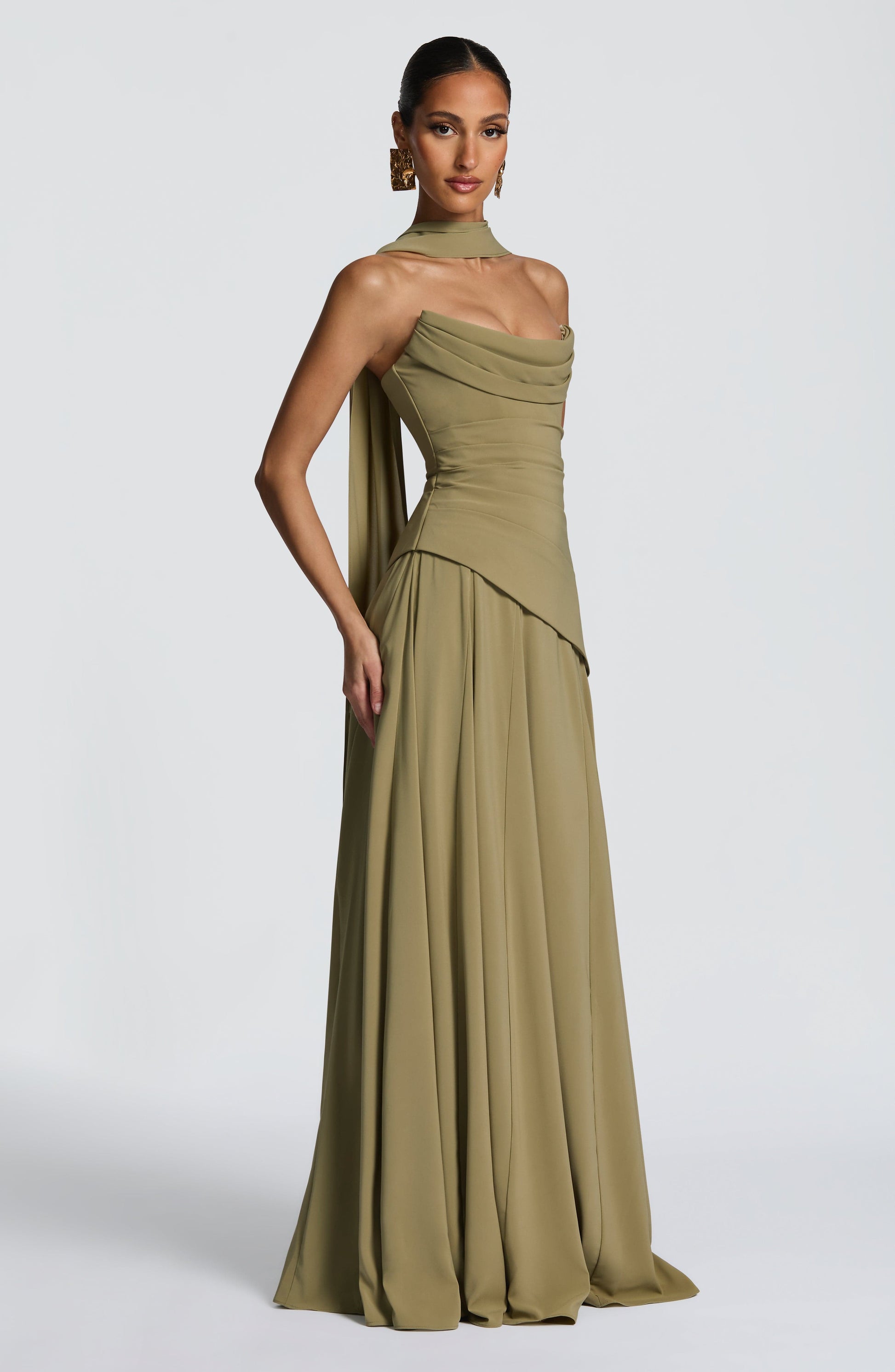 Side view of an olive green strapless cowl neck maxi dress, showcasing the structured bodice and pleated skirt details.