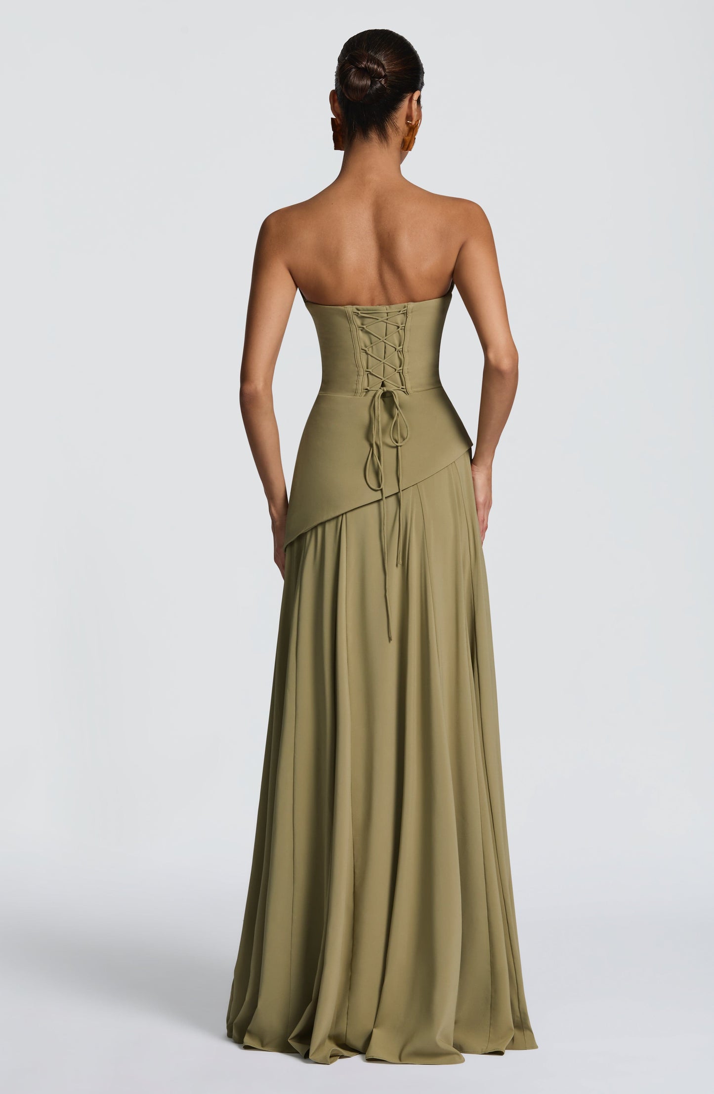 Back view of the olive green strapless maxi dress, highlighting the intricate lace-up corset detail on the bodice.