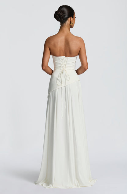 Rear view of the white strapless maxi dress, showing the elegant lace-up back closure and flowing skirt.
