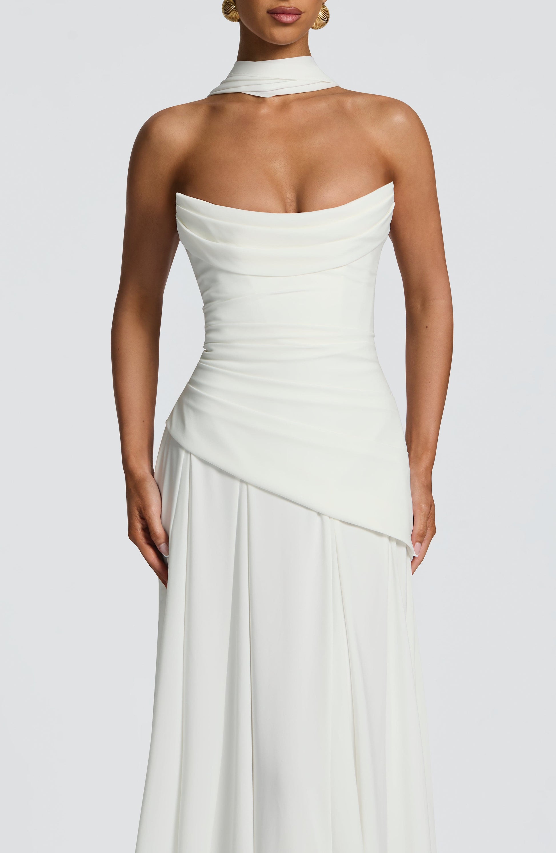 Close-up of the bodice of the white strapless cowl neck maxi dress, showing the draped neckline and fitted waist.