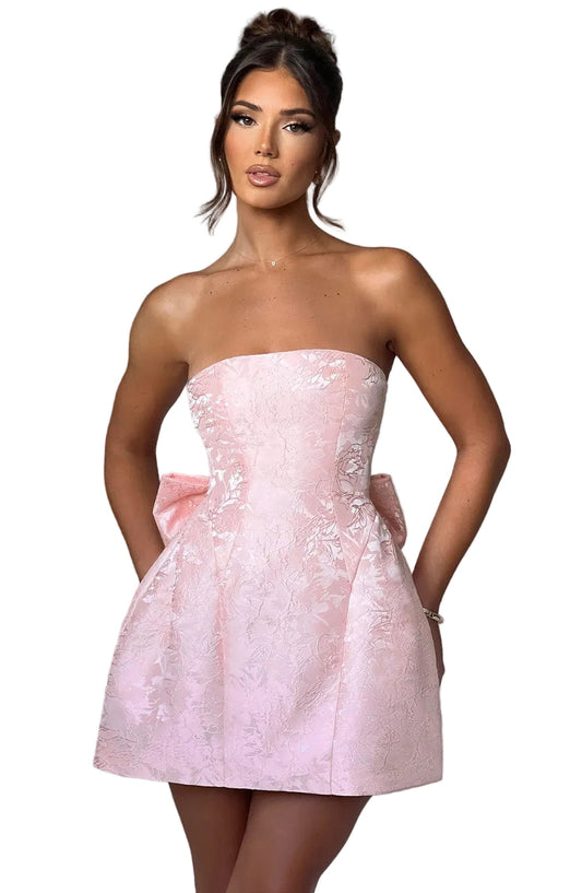Front view of a women's strapless floral bow mini dress in light pink, featuring a large decorative bow on the side.
