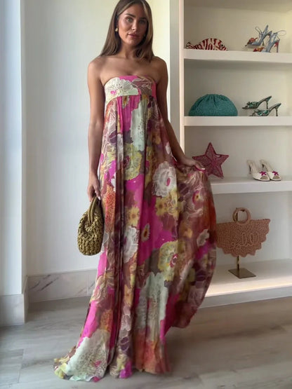Women's strapless floral printed maxi dress in pink and yellow hues, featuring a loose, comfortable fit and a subtle side slit, ideal for vacation outfits.