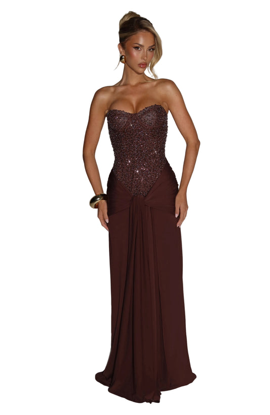 Front view of a women's strapless formal maxi dress in dark brown with an embellished sequin bodice and draped skirt detail.