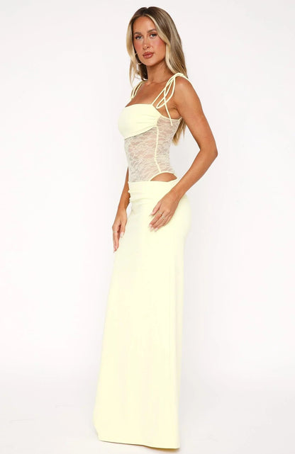 Side profile of a woman wearing a light yellow strapless lace cut out maxi dress, featuring delicate lace detailing on the bodice and a flowing skirt, perfect for vacation outfits.