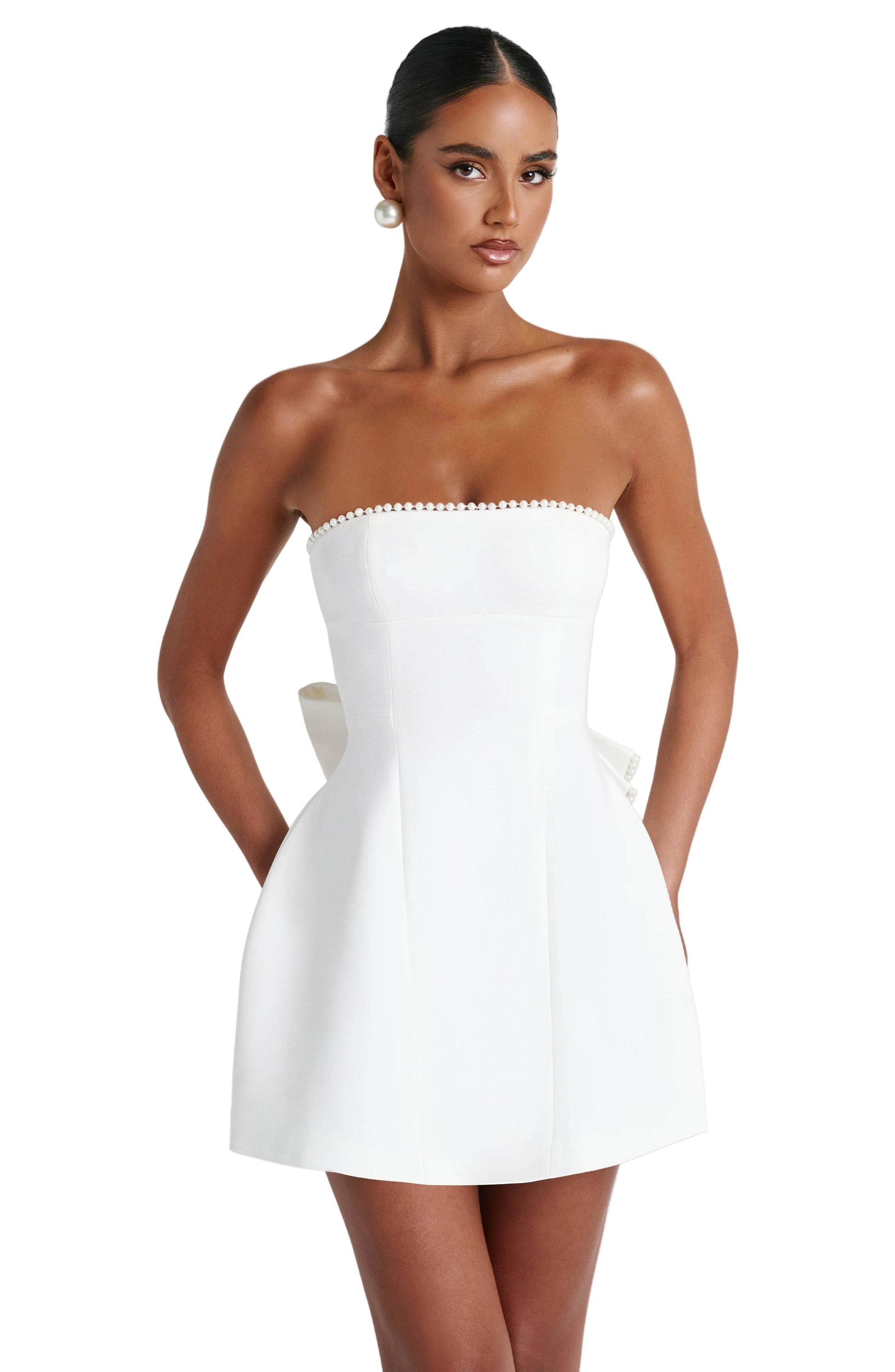 Front view of a white strapless mini dress with pearl trim along the neckline and a subtle back bow detail.