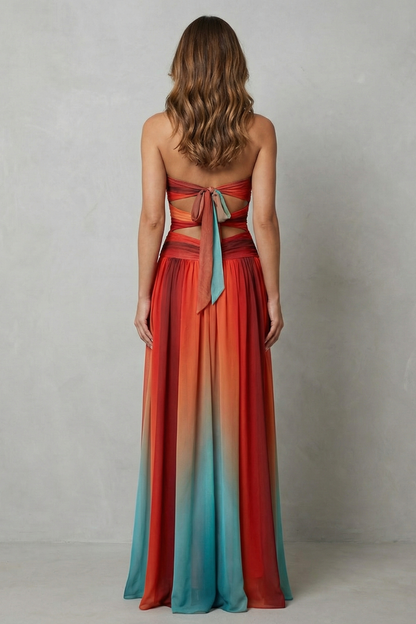 Back view of a women's strapless ombre maxi dress with a tie-back closure and waist cut-outs, in rich orange and red tones.