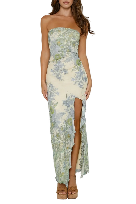 Front view of a strapless maxi dress with a cream base and blue-green floral print, featuring a ruffled thigh-high slit.