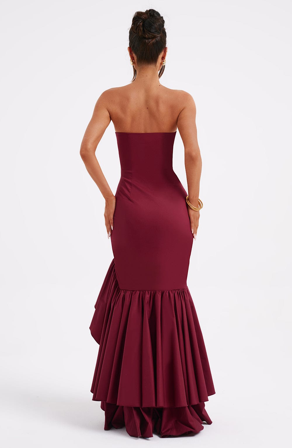 Back view of the burgundy strapless ruffle high-low maxi dress, showcasing the gathered ruffles at the hem.