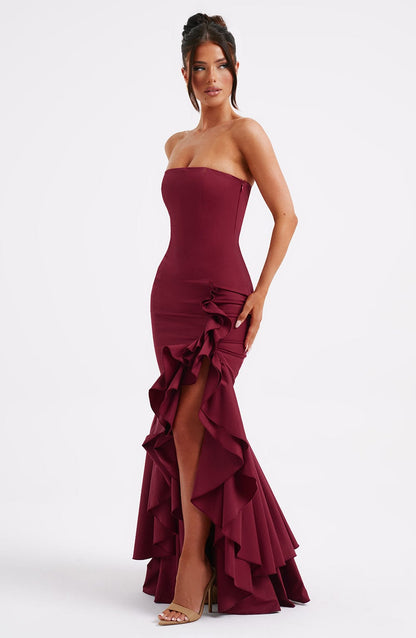 Front view of a women's strapless ruffle high-low maxi dress in a rich burgundy color, featuring a fitted bodice and dramatic ruffled high-low hemline.