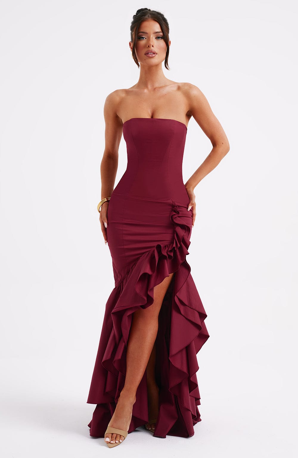 Burgundy strapless ruffle high-low maxi dress with a fitted top and layered ruffles on the skirt, front view.