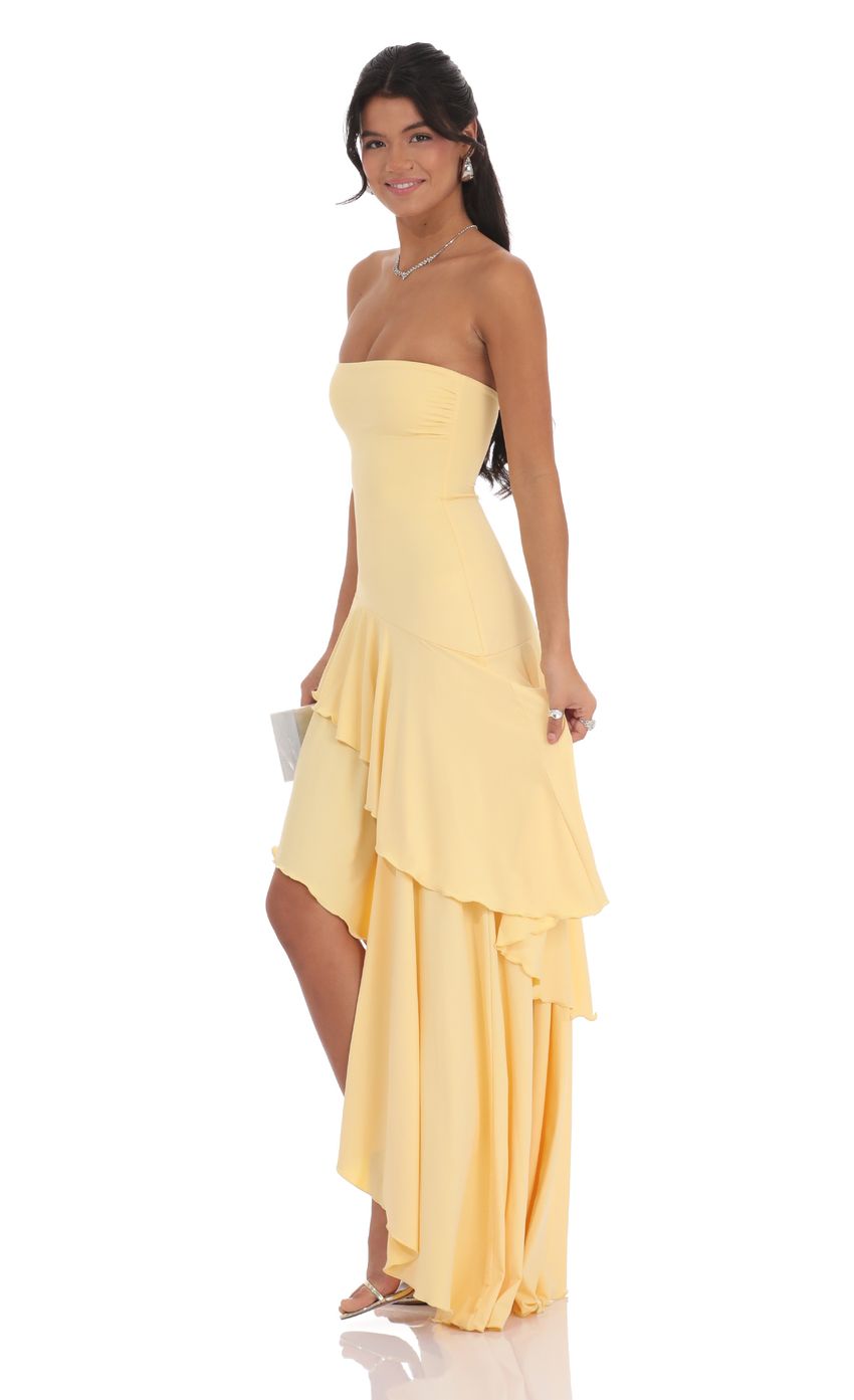 Pale yellow strapless high-low maxi dress, side view showing layered ruffle skirt and fitted bodice