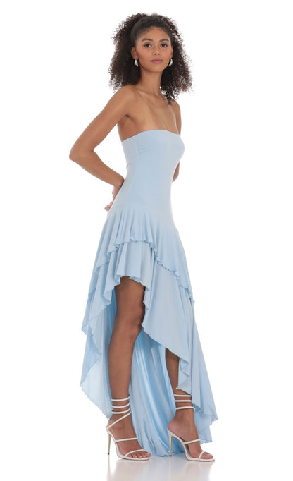 Light blue strapless high-low maxi dress, angled side view highlighting flowing ruffle layers