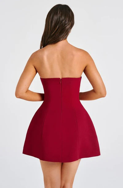 Back view of the deep berry red strapless seamed bubble mini dress, revealing the form-fitting top and voluminous skirt.