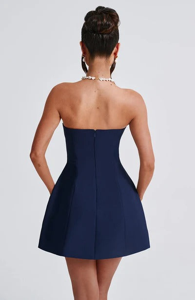 Back view of a navy blue strapless seamed bubble mini dress, showing the fitted bodice and a discreet zipper closure.