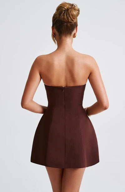 Back view of a dark brown strapless seamed bubble mini dress, showcasing the full skirt and clean lines.