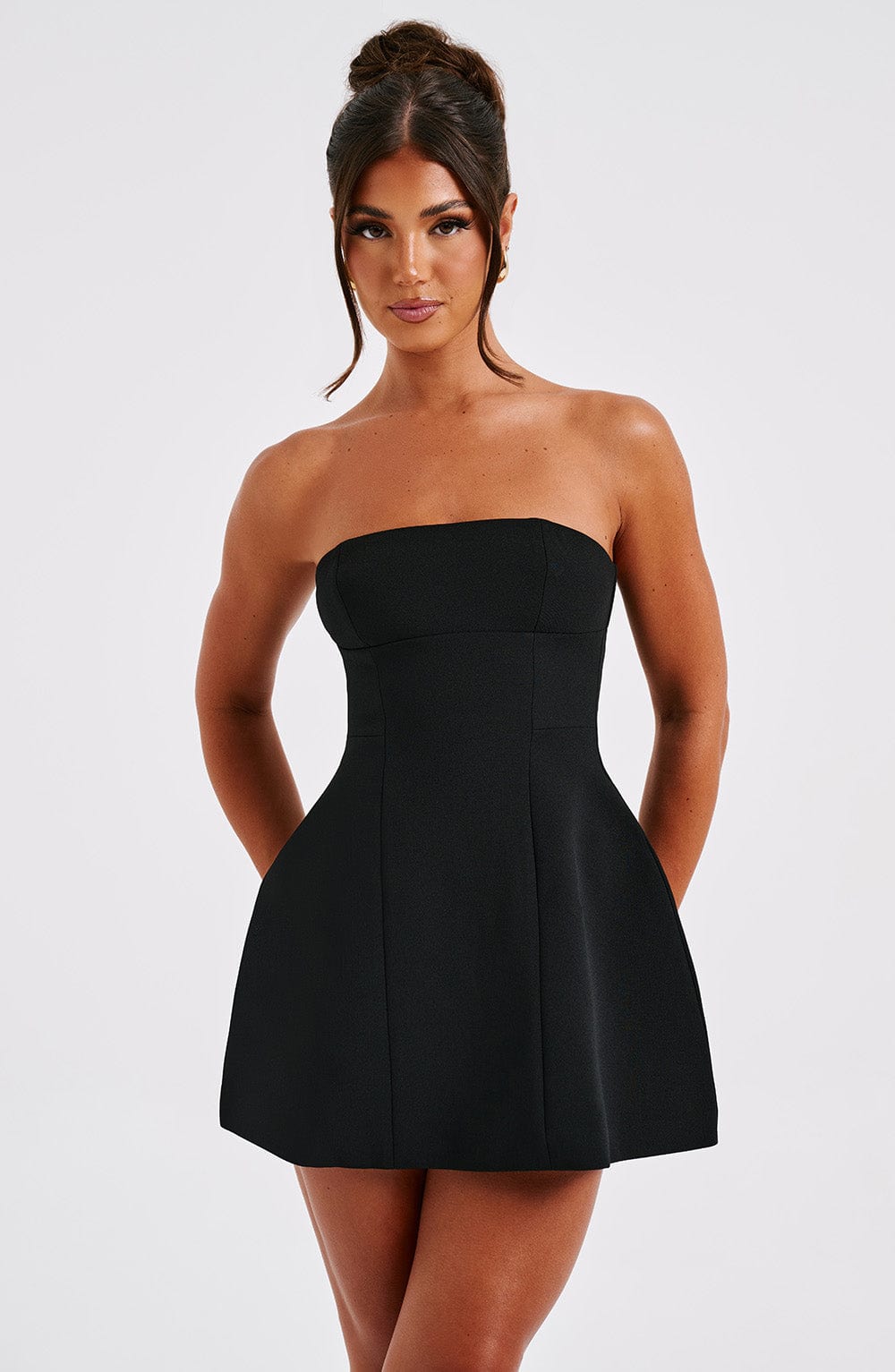 Close-up of a black strapless seamed bubble mini dress, showing bodice detail and a subtle flare.