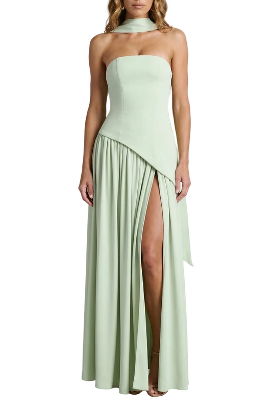 Light green strapless maxi dress with asymmetric slit and flowing skirt, perfect for a vacation outfit.