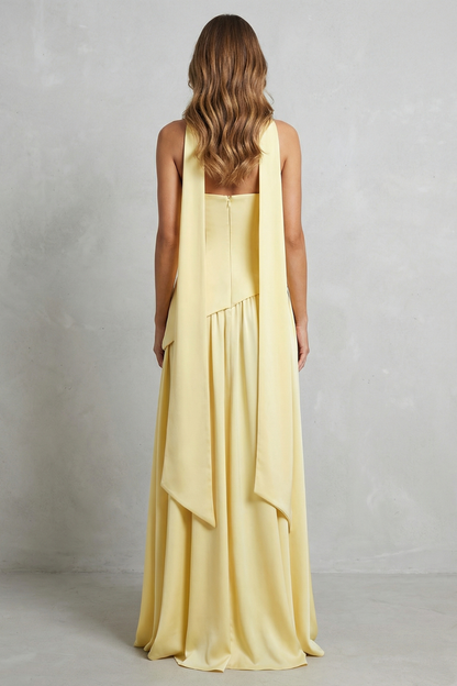 Back view of the pale yellow strapless maxi dress, showing the flowing draped neck detail extending down the back, elegant for wedding guests.