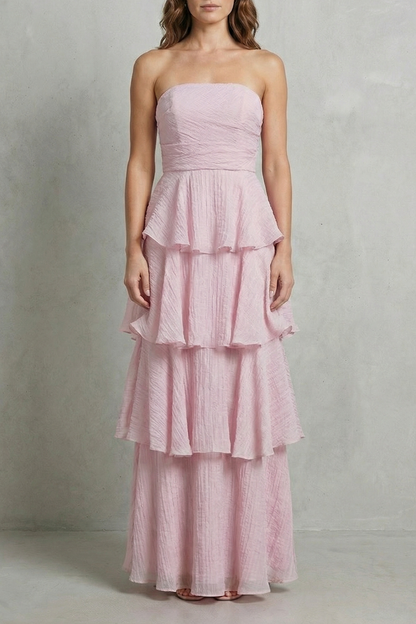 Full-length view of a light pink strapless tiered ruffle maxi dress, featuring a crinkled texture, perfect for vacation outfits.