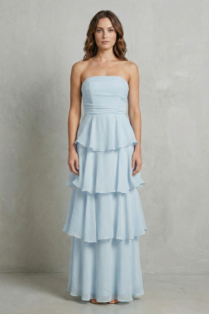 Front view of a woman in a light blue strapless tiered ruffle maxi dress, with a delicate tiered skirt.