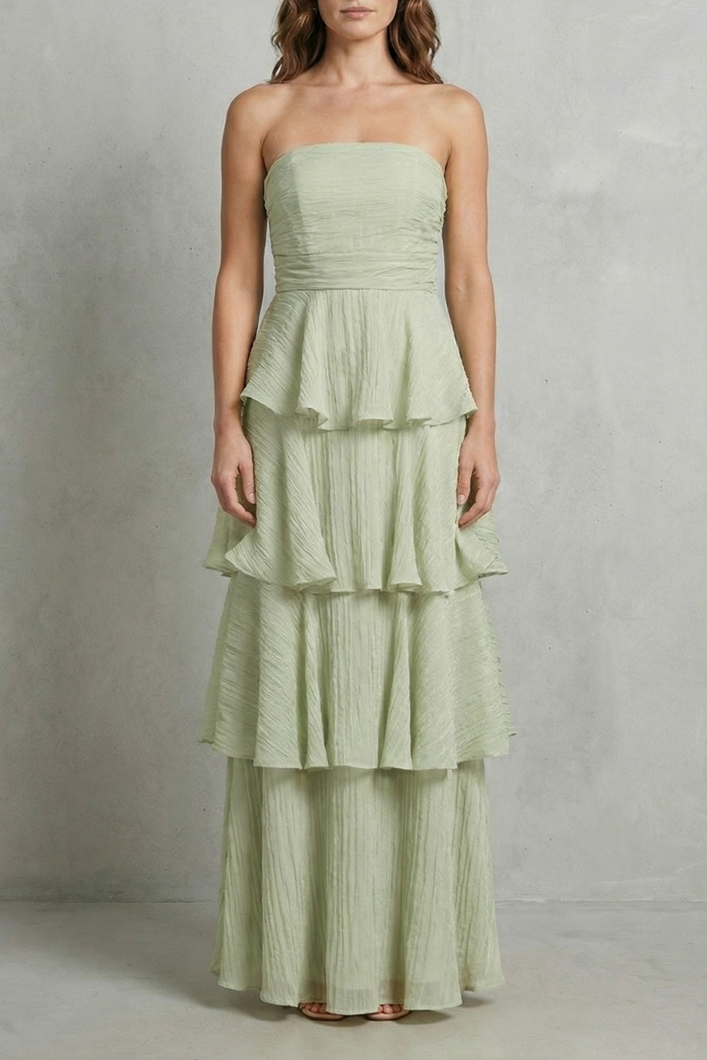 Full-length view of a sage green strapless tiered ruffle maxi dress, a stylish vacation dress.